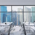 Workplaces in a modern panoramic office, Singapore city view from the windows. Open space. White tables and black leather chairs. A concept of financial consulting services. 3D rendering.