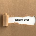 The text COMING SOON behind torn brown paper