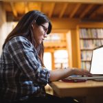 Female student using laptop in library