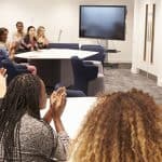 Female teacher addressing university students in a classroom